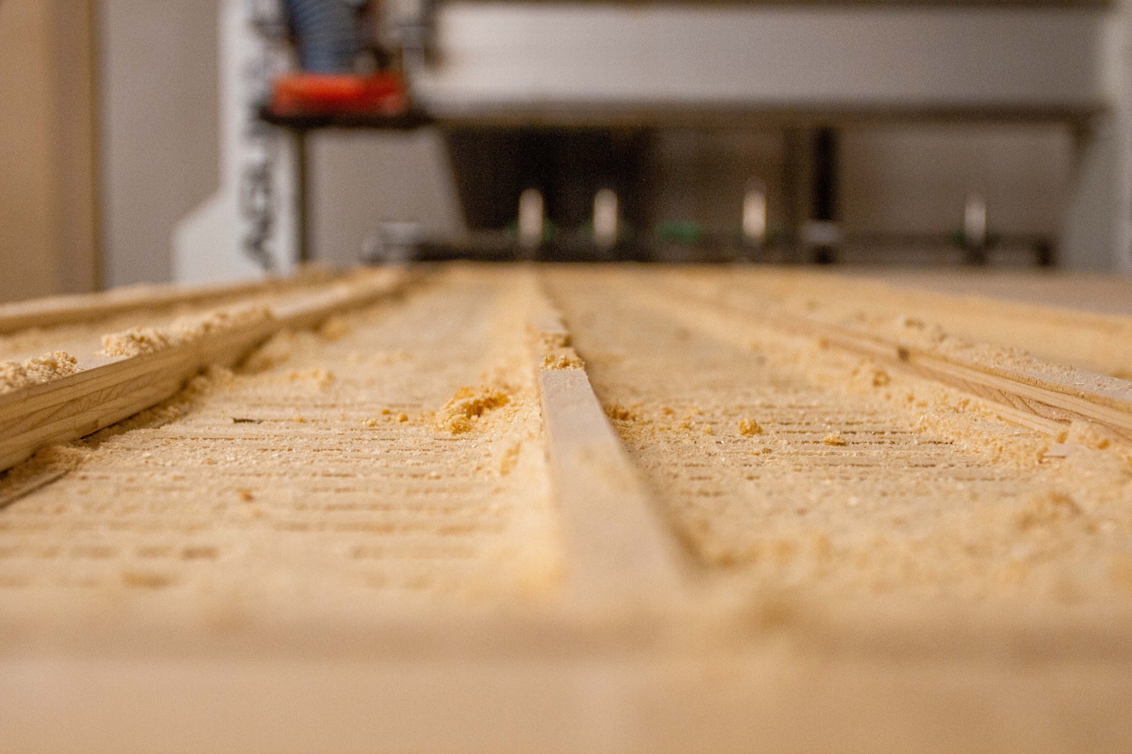 CNC router cutting routed channels in a wood panel in the fabrication shop